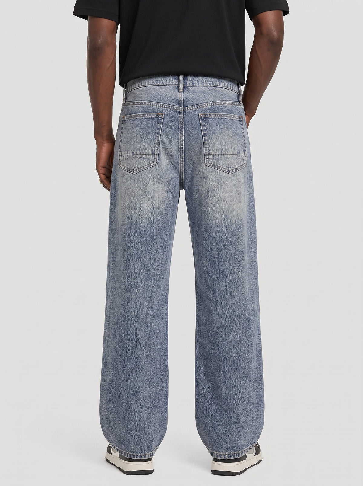 Model wearing B704 men's wide-leg denim jeans in Dusty light Blue, back view