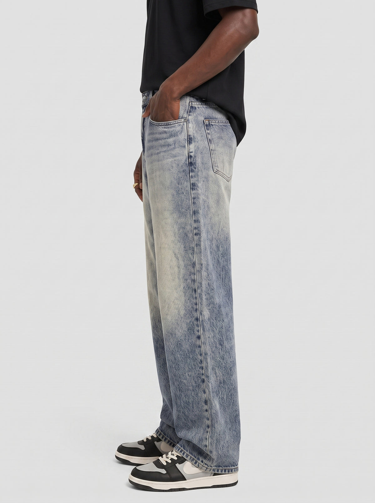 Model wearing B704 men's wide-leg denim jeans in Dusty light Blue, side view