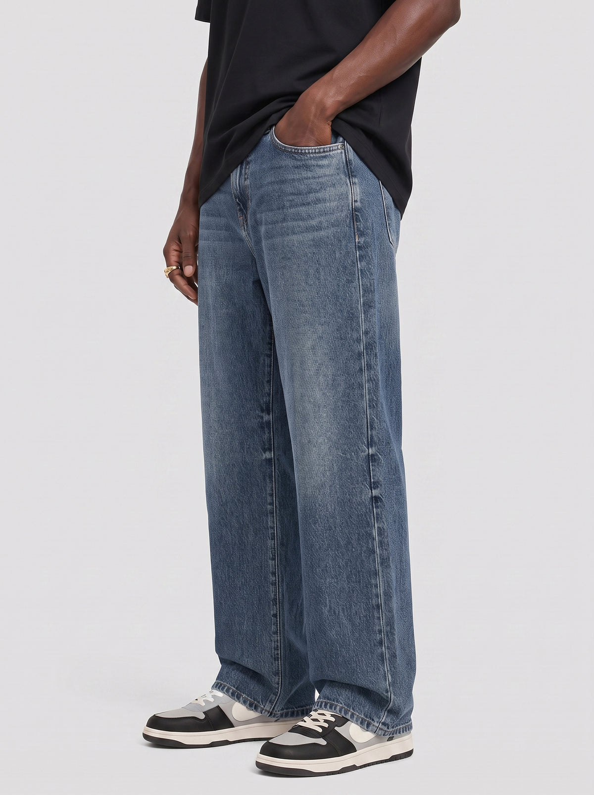 Model wearing B704 men's wide-leg denim jeans in Dark Blue, side view